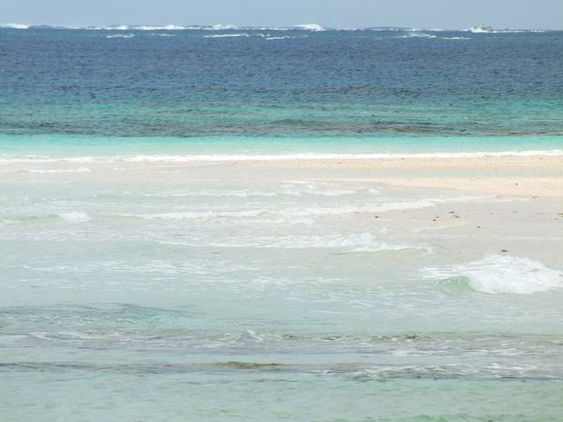 久米島のはての浜、白い砂に寄せる波とサンゴ礁の海